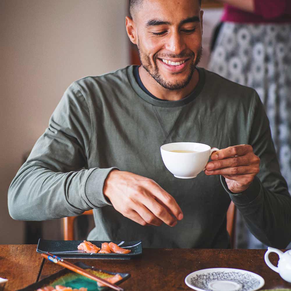 image of a man enjoying a cup of chinese whole leaf green tea