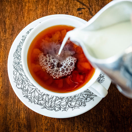 pouring milk into a cup of Single Estate Lost Malawi English Breakfast tea