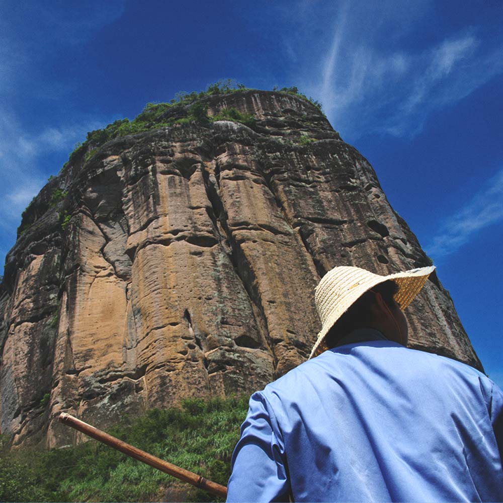 chinese man in front of large mountain in china