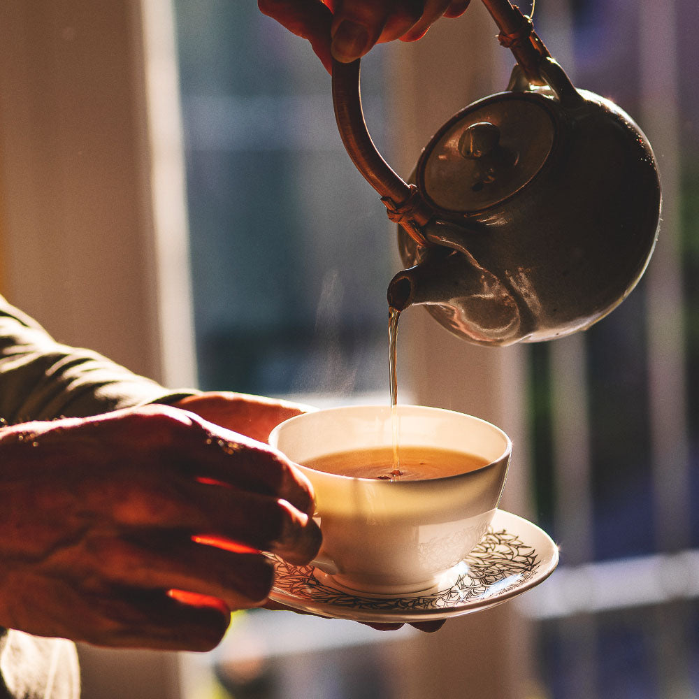 pouring a teapot of our Chinese Emperor's Breakfast loose leaf tea into a mug