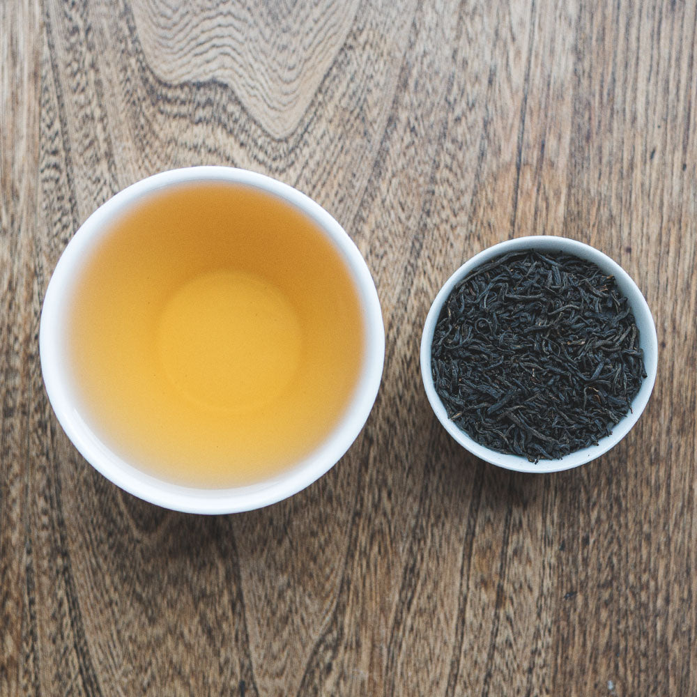 comparison of a mug of Rare Chinese Keemun tea and the individual leaves in a bowl