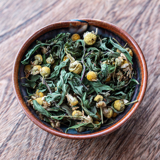 bowl of Soothe-Me Tea showing the chamomile flowers and basil